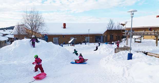 Barn som leker på förskolans gård i vinter