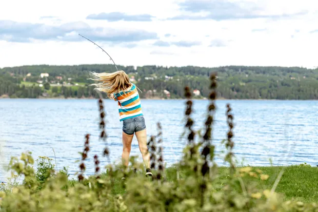 En flicka fiskar från en brygga