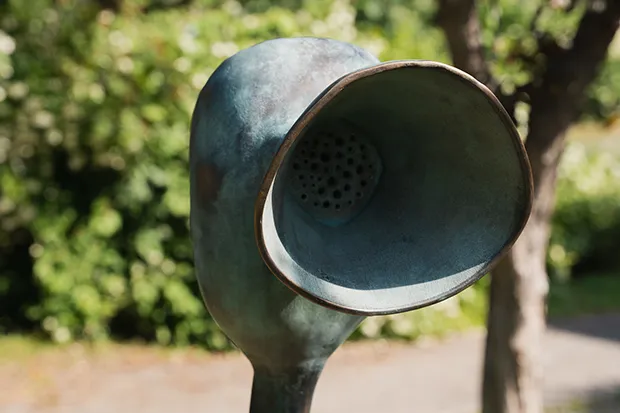 En metallskulptur mitt i en park.
