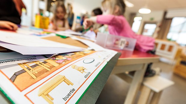 Barn i oskärpa bakom utbnildningsmaterial