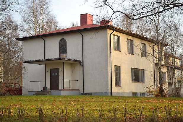 Villa i vit puts, två våningar, rött plåttak.