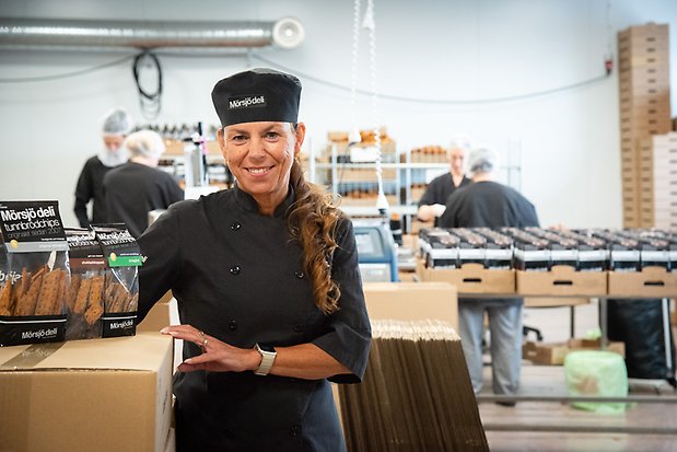 Anna står med nypackade kartonger