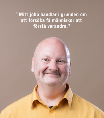 En kvinna med en blå arbetströja och namnbricka på bröstet.