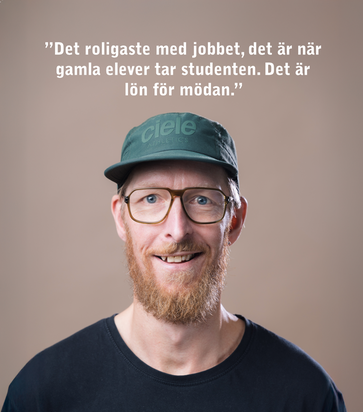 En kvinna med en blå arbetströja och namnbricka på bröstet.
