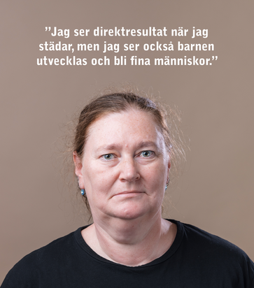 En kvinna med en blå arbetströja och namnbricka på bröstet.