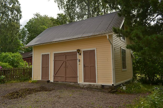 Flädern 3, Uthus med gul, liggande panel och bruna dörrar.