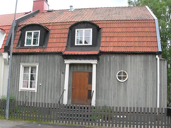 Forellen 7, Villa med grå, stående panel och rött tegeltak.