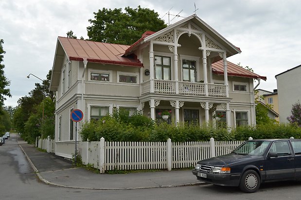 Gullvivan 9, Villa i grå träpanel med balkong med snickarglädje.