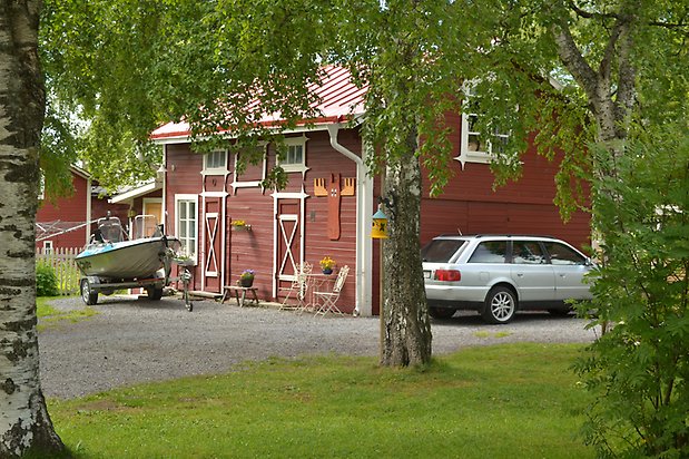 Konvaljen 5, Byggnad i röd, liggande träpanel och ladugårdsdörrar med vita kryss på.