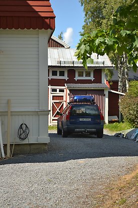 Konvaljen 7. byggnad i röd, liggande träpanel med ladugårdsdörrar med vitt kryss på.