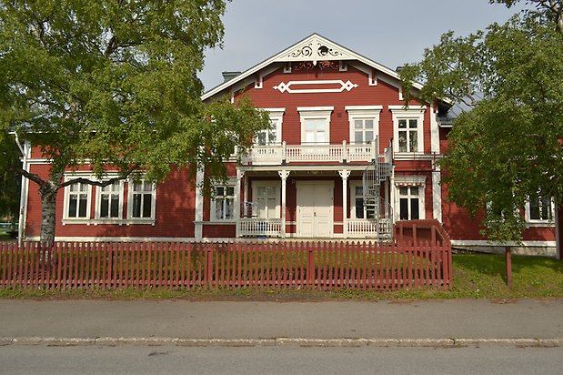 Linnean 1, Villa i röd träpanel, med balkong och snickarglädje.