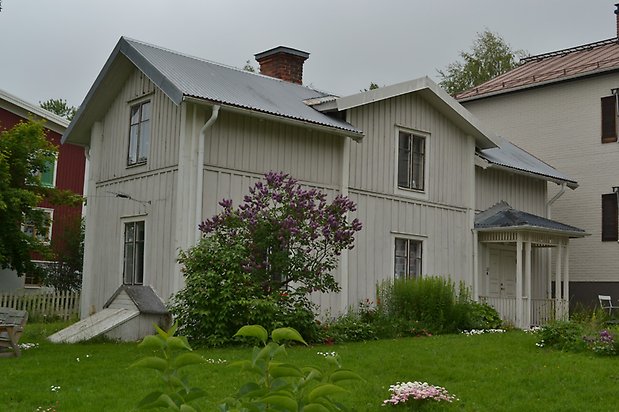 Majsen 8, Hus med ljusgrå träpanel och svarta fönster med spröjs.