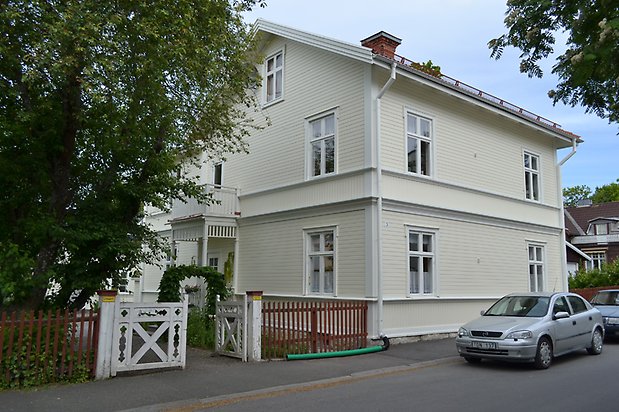 Nejlikan 7, Villa i vit, liggande träpanel och vita fönster med spröjs.