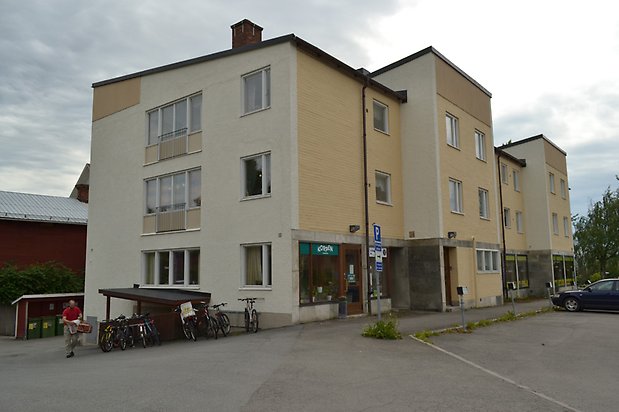 Nejlikan 10, Flerbostadshus i tre våningar, vit och gul puts med vita fönster och franska balkonger.