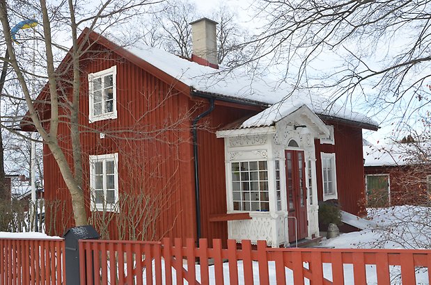 Odenslund 3:3, Villa i röd träpanel, vita fönster med spröjs och en förstukvist med mycket vit snickargläjde.