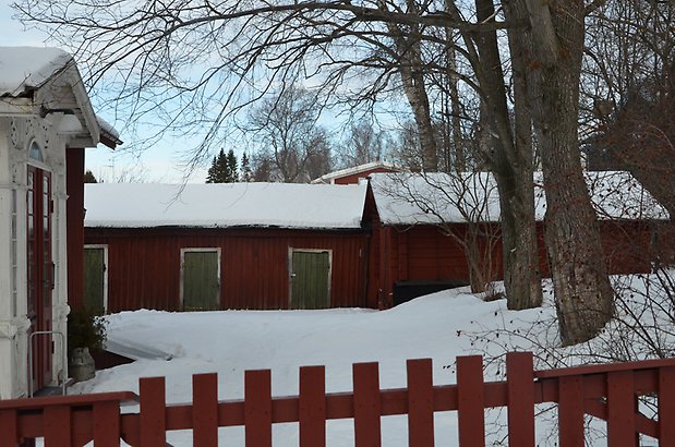 Odenslund 3:3. Uthus i röd träpanel och gröna dörrar.