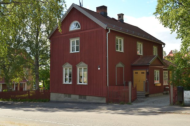 Siken 4. Villa i röd träpanel, gul dörr och vita fönster med spröjs.