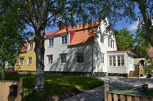 Öringen 9, Villa i vit träpanel, vita fönster med röda spröjs och rött tegeltak.