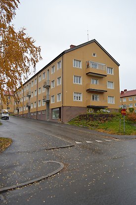 Abborren 3. Flerbostadshus i gul panel och vita fönster och gula balkonger.