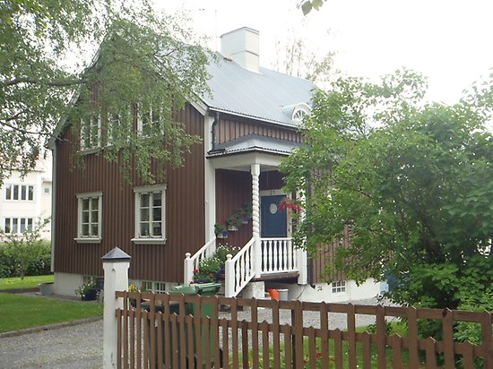 Klövern 13, Villa med brun träpanel, vita fönster och spröjs och blå dörr.