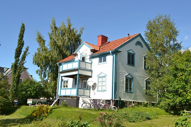 Laken 2, Villa i vit, liggande panel och blå detaljer, blå fönster med spröjs och rött tegeltak.