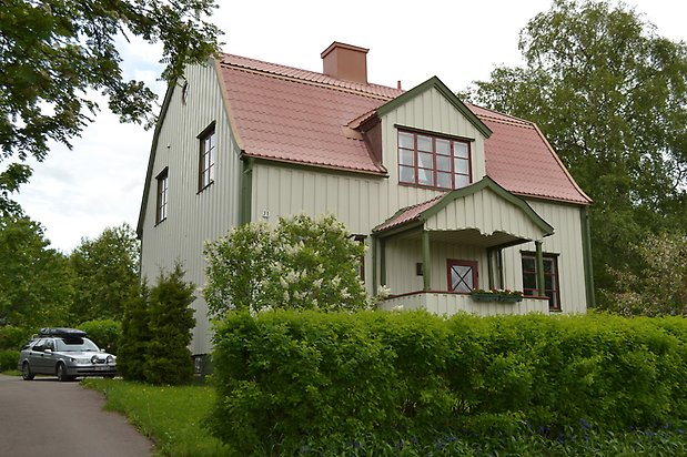 Rödingen 11, Villa i ljusgrön träpanel och mörkgröna detaljer och mörkröda fönster med spröjs.