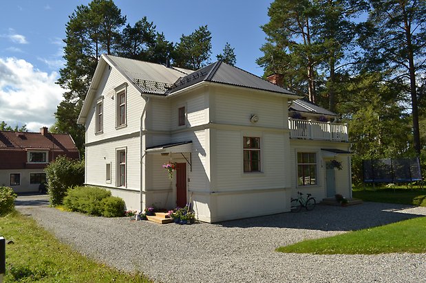 Sälgen 2, Villa i vit, liggande träpanel och vita fönster med röda spröjs.