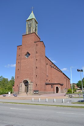 Braxen 2, Kyrka i brunt tegel med svart klockstapel med detaljer i guld och grön tak.