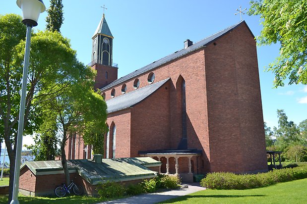 Braxen 2, Kyrka i brunt tegel med svart klockstapel med detaljer i guld och grön tak.