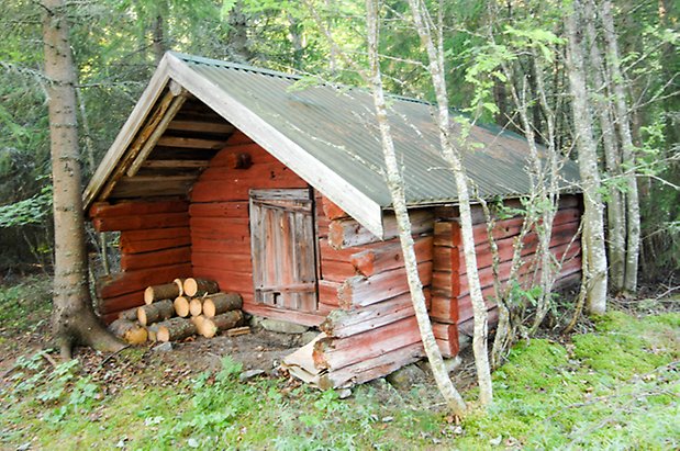 Timrad byggnad med avskavd röd färg.