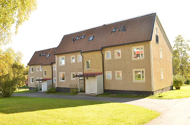 Mariedal 15. Flerbostadshus i två våningar, i beige puts och gult tegel med vita fönster.