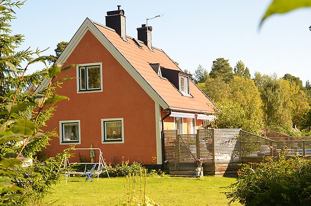 Mariedal 17. Villa i röd puts med vita detaljer och svarta fönster, en takkupa.