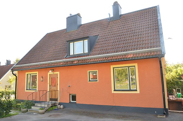 Mariedal 18. Villa i röd puts med ljusgula detaljer och svarta fönster.