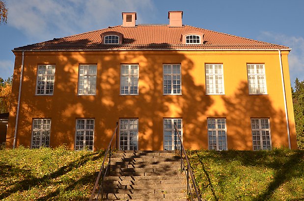 Frösö 3:7. Byggnad i två våningar, i gul puts med stora vita fönster med spröjs.