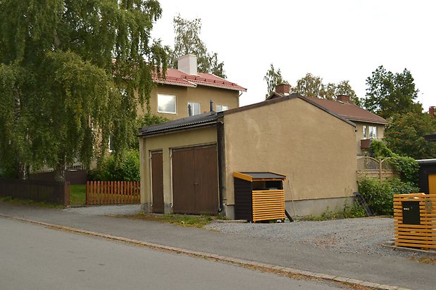 Grävlingen 1 - Garage med beige puts och brun dörr.