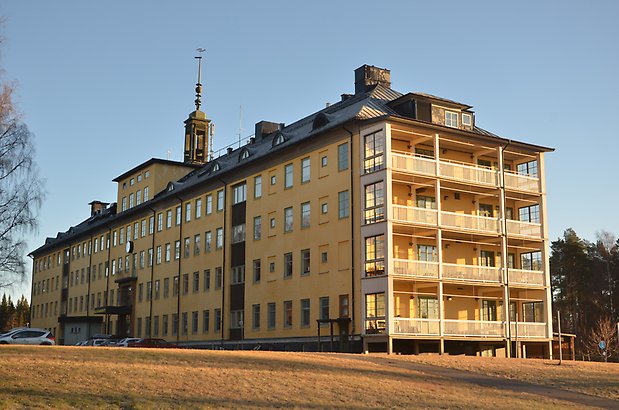 Karlslund 2:1 - Stort gammalt hus i ljusgult med klocktorn och balkonger.