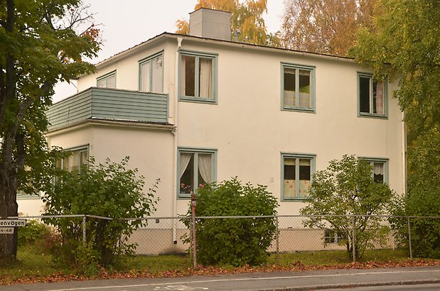 Mården 4 - Hus i beige puts med ljusgröna fönster och balkong med ljusgrönt staket.