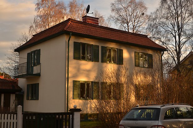 Rådjuret 8 - hus med ljusgul puts, gröna fönsterluckor och balkong med smidesstaket.