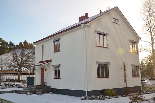 Lodjuret 6 . Vitt hus med röda fönster och stentrapp.