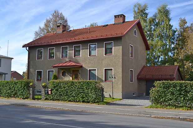 Mården 3 -  Bostadshus i grå puts och vita fönster.