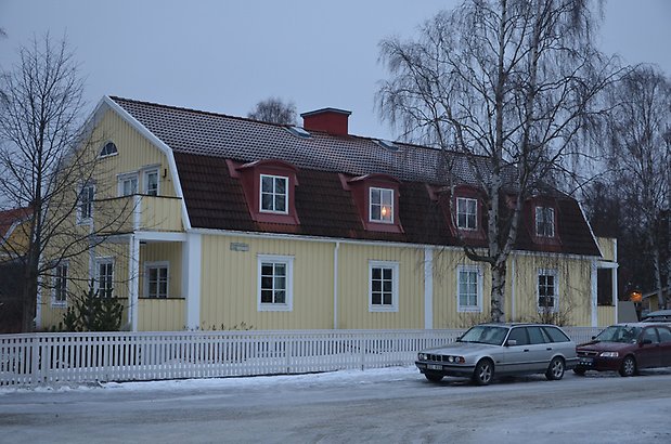 Vesslan 1-6 - Bostadshus med ljusgul panel och rött tegeltak med takkupor.