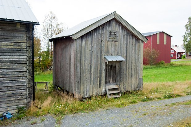 Boda 1:4. Liten byggnad i grånad träpanel.