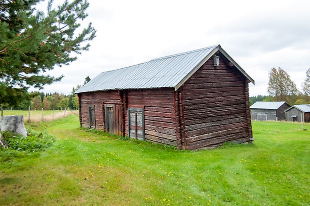 Boda 1:4. Timrad byggnad med grå portar.