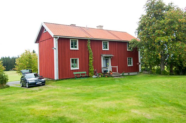 Boda 1:6. Hus i två våningar i röd panel med fönster med gröna spröjs.