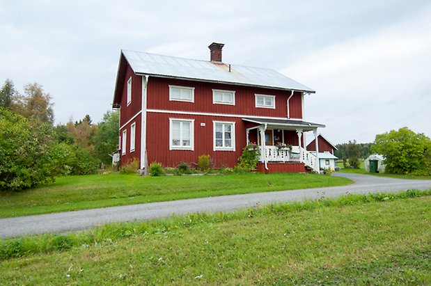 Boda 1:7. Villa i två våningar i röd panel med vita detaljer.