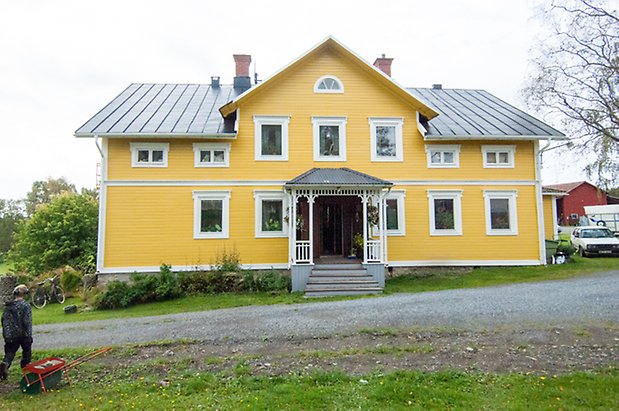 Boda 3:1. Villa i gul liggande panel med vit förstukvist.