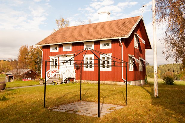 Brevåg 1:12. Hus i två våningar i röd panel med fönster med vita spröjs och vita dubbeldörrar.