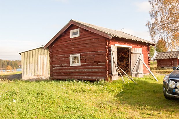 Brevåg 1:12. Timrad, rödmålad byggnad med öppna dubbelportar och fönster med vita spröjs