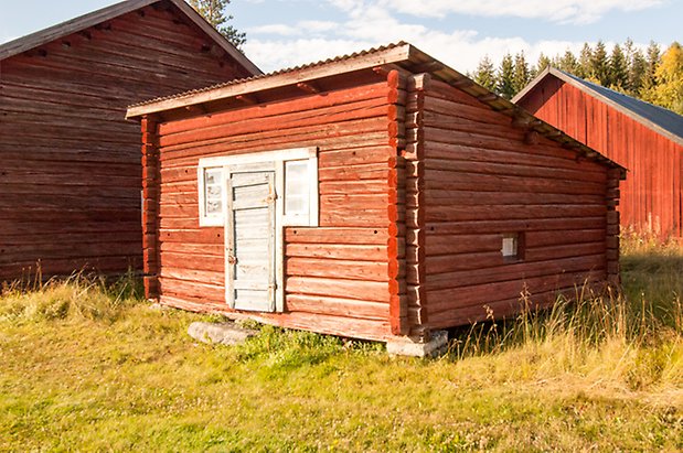 Brevåg 5:1. Timrad, rödmålad byggnad med grå dörr och fönster.