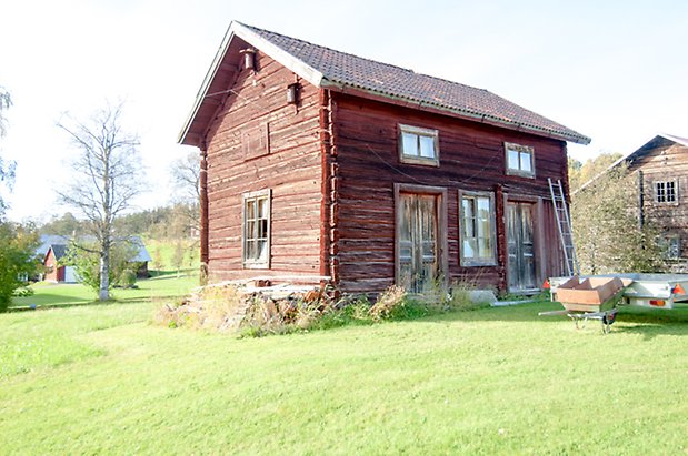 Byom 1:15. Timrat hus med två dubbeldörrar och fönster med spröjs.